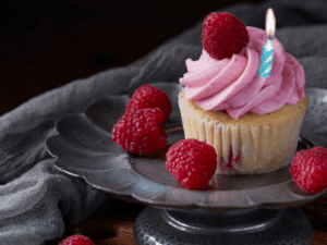 Happy birthday gif showing a raspberry cupcake, fireworks of stars, and 3 lines of animated text to customize.
