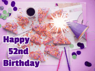 Happy Birthday Age 52 GIF, 52nd Birthday GIF: A big paper sparkle highlights this animated birthday gif showing a birthday cake place setting with decorations.