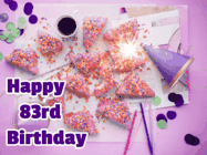 Happy Birthday Age 83 GIF, 83rd Birthday GIF: A big paper sparkle highlights this animated birthday gif showing a birthday cake place setting with decorations.