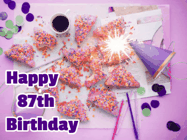 Happy Birthday Age 87 GIF, 87th Birthday GIF: A big paper sparkle highlights this animated birthday gif showing a birthday cake place setting with decorations.