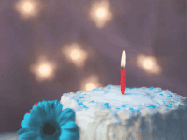 Happy Birthday Alexis GIF: Animated birthday gif of a blue flower next to a cake, colorful fireworks, flickering candle, and name to customize