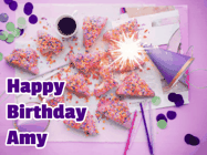Happy Birthday Amy GIF: A big paper sparkle highlights this animated birthday gif showing a birthday cake place setting with decorations.