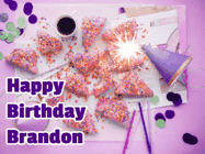 Happy Birthday Brandon GIF: A big paper sparkle highlights this animated birthday gif showing a birthday cake place setting with decorations.