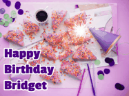 Happy Birthday Bridget GIF: A big paper sparkle highlights this animated birthday gif showing a birthday cake place setting with decorations.