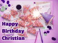 Happy Birthday Christian GIF: A big paper sparkle highlights this animated birthday gif showing a birthday cake place setting with decorations.