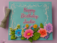 Happy Birthday Jackie GIF: Animated Birthday GIF as a colorful birthday card reading Happy Birthday Name and flower petals floating past.