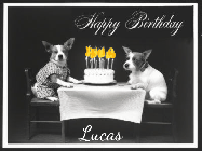 Happy Birthday Lucas GIF: Vintage animated birthday card gif with name, flickering candles, birthday cake, and 2 dogs sitting at the table.