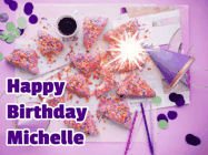Happy Birthday Michelle GIF: A big paper sparkle highlights this animated birthday gif showing a birthday cake place setting with decorations.