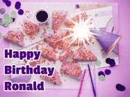 Happy Birthday Ronald GIF: A big paper sparkle highlights this animated birthday gif showing a birthday cake place setting with decorations.