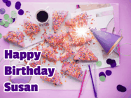 Happy Birthday Susan GIF: A big paper sparkle highlights this animated birthday gif showing a birthday cake place setting with decorations.