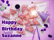 Happy Birthday Suzanne GIF: A big paper sparkle highlights this animated birthday gif showing a birthday cake place setting with decorations.