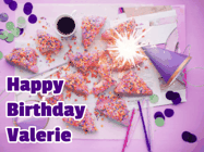 Happy Birthday Valerie GIF: A big paper sparkle highlights this animated birthday gif showing a birthday cake place setting with decorations.